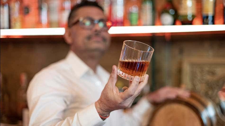 Neeraj Bakshi, owner of NB Distillers, holding a glass of whisky.