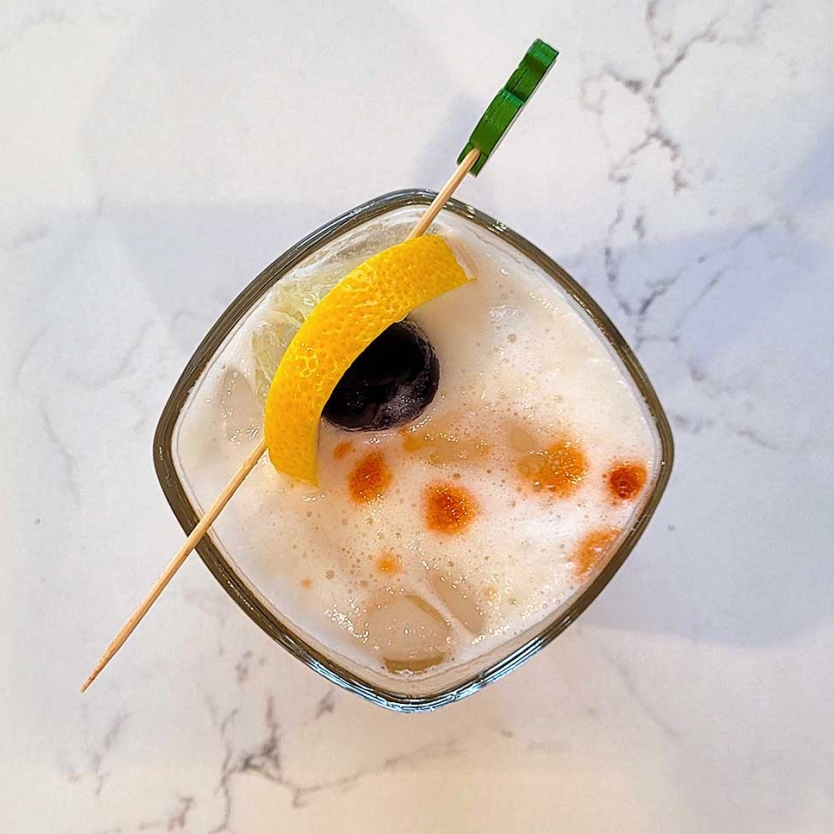 The Amaretto Sour with a lemon and bourbon cherry garnish.