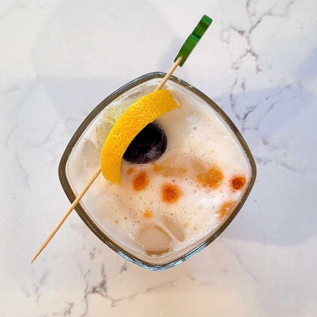 The Amaretto Sour with a lemon and bourbon cherry garnish.