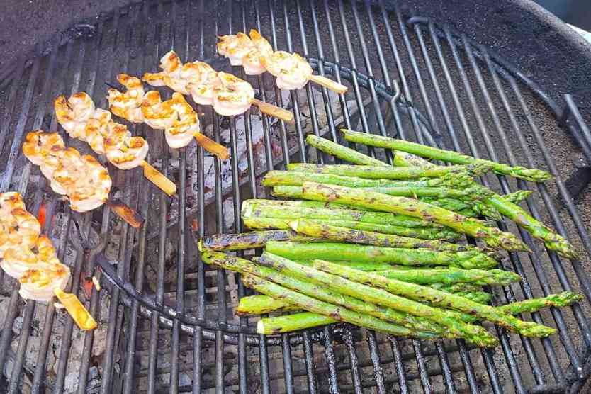 Tequila lime marinated shrimp and asparagus on a charcoal grill.