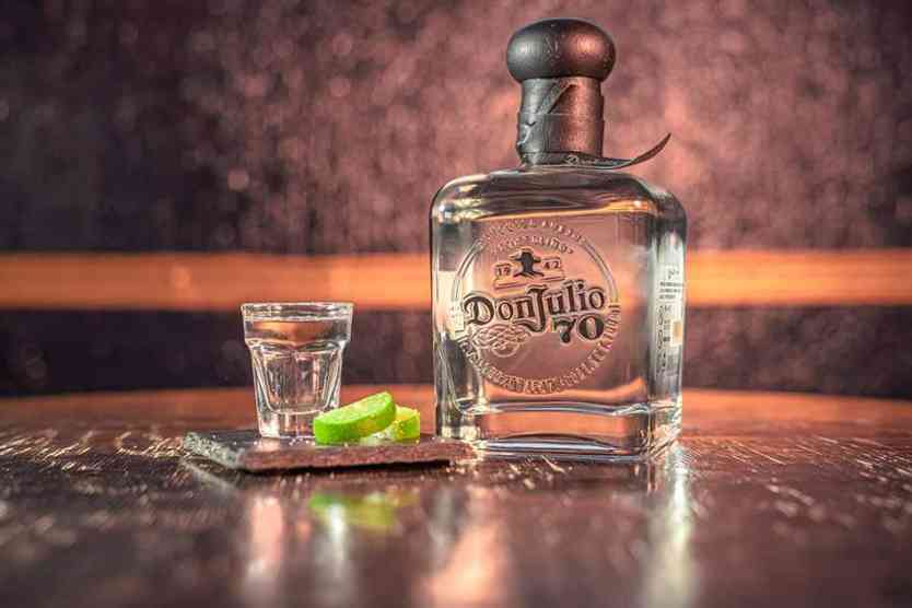 Don Julio 70 Tequila bottle with lime slices.
