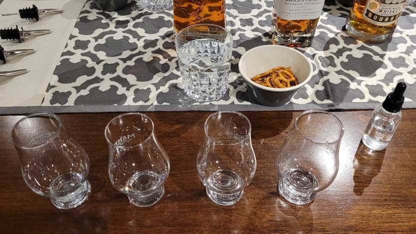 Table with Glencairn glasses, pretzels, and water for a whisky tasting.