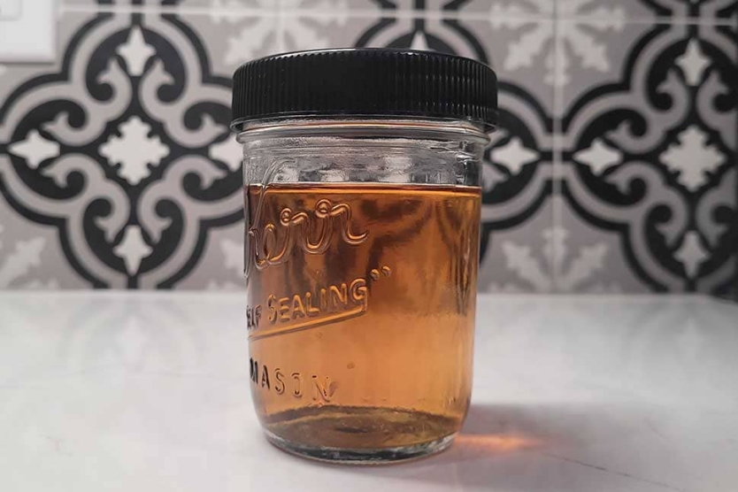 Jar of bacon fat-washed bourbon ready to be used in your favourite cocktails.