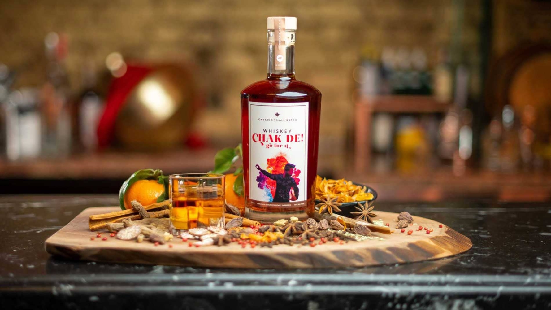 Citrus and Whisky Highball cocktail with a bottle of whisky.